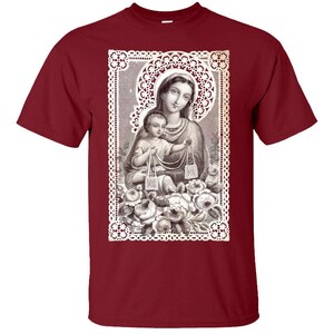 Puede incluir: Una camiseta de color granate con una imagen vintage de la Virgen Mar&iacute;a y el ni&ntilde;o Jes&uacute;s. La imagen est&aacute; enmarcada con un dise&ntilde;o de encaje blanco y rodeada de rosas blancas.