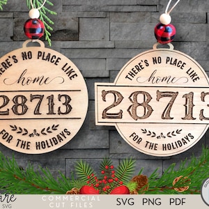 Puede incluir: Dos adornos navideños de madera con el texto "THERE'S NO PLACE LIKE home" y "28713". Uno es redondo, el otro rectangular. Ambos tienen una cuenta decorativa y un acento a cuadros. También se incluye la frase "FOR THE HOLIDAYS".