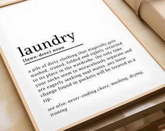May include: A black and white typography print with the word "laundry" defined as a pile of dirty clothing that magically gets washed, ironed, folded and returned to its place in the wardrobe. The print also includes the text "see also: never-ending chore, washing, drying, ironing."