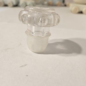 Può includere: Una tazza di ceramica bianca con manico nero e la scritta "But First, Coffee" in nero, con un carattere a mano. La tazza è su una superficie bianca.