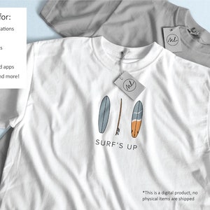 Op de afbeelding: Wit T-shirt met een afbeelding van drie surfplanken in blauw, bruin en oranje, met de tekst "SURF'S UP". Een grijs T-shirt is gedeeltelijk zichtbaar op de achtergrond. De afbeelding bevat een label met de letters "ML".