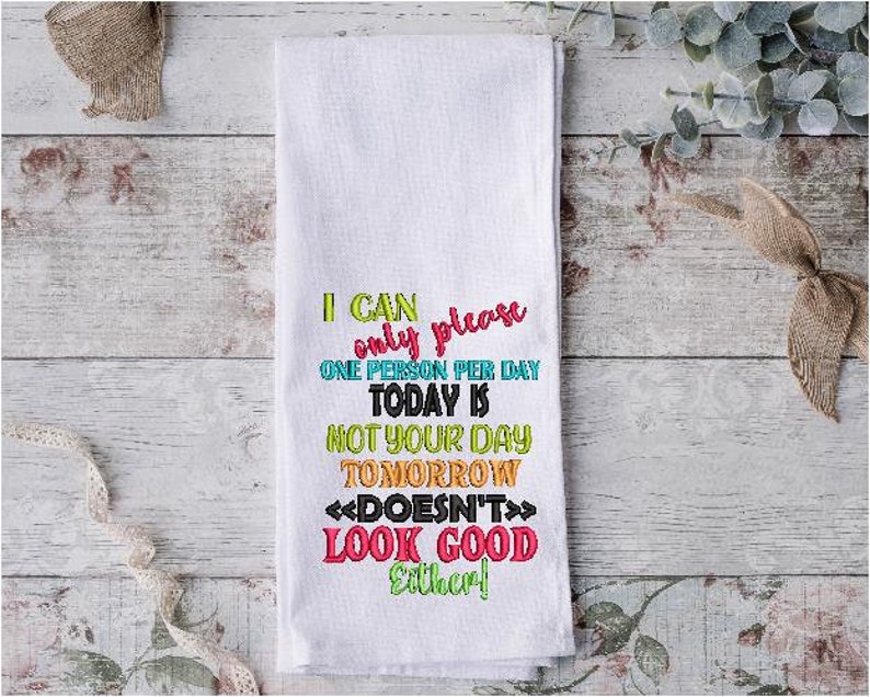 May include: White kitchen towel with colorful embroidered text that reads "I can only please one person per day. Today is not your day. Tomorrow doesn't look good either!"