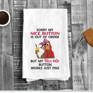 May include: White kitchen towel with an embroidered image of a turkey wearing a pink hat and holding a glass of orange juice. The text reads "Sorry my nice button is out of order but my bite me button works just fine."