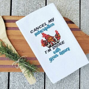 May include: White kitchen towel with an embroidered design of three chickens and the text "CANCEL MY SUBSCRIPTION I'M DONE WITH YOUR ISSUES".