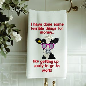 Puede incluir: Toalla de cocina blanca con una vaca negra y blanca que lleva gafas de sol rosas. El texto en la toalla dice "He hecho algunas cosas terribles por dinero... como levantarme temprano para ir a trabajar!"