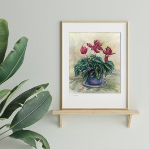 May include: Watercolor painting of a potted plant with red flowers. The plant is in a blue pot with a white and blue saucer. The background is a light yellow.