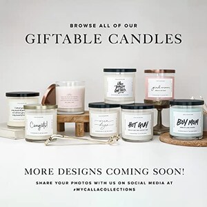 Pu&ograve; includere: Assortimento di candele profumate in vasetti di vetro con coperchi neri. Le candele hanno diverse etichette con testo come "You Totally Got This", "Girl Mom", "Congrats!" e "Hot Guy". Le candele sono disposte su una superficie bianca con un supporto in legno.