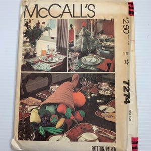 May include: Vintage McCall's sewing pattern envelope with images of festive table settings. The cover shows a cornucopia, a Christmas tree, and other holiday table decor. The text "McCall's" is at the top, with the price and pattern number on the right.