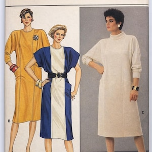 Può includere: Un modello di cucito Butterick vintage con tre modelli di abiti. Gli abiti includono un abito giallo senape, un abito a blocchi di colore blu e bianco e un abito color crema. Il numero del modello è 6943, con taglie 14-16-18.