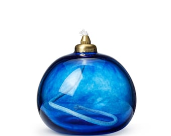 May include: A blue glass oil lamp with a brass top and a white wick.