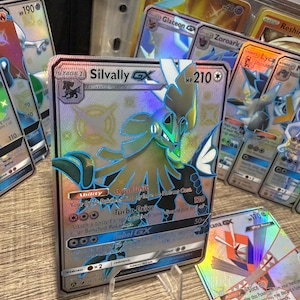 May include: Silvally GX Pokemon card with a holographic finish. The card features a blue and green Silvally with a white background. The card has a HP of 210 and has the text "Gyro Unit" and "Turbo Drive" on it.