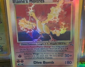 Può includere: Una carta Pokémon olografica con Blaine's Moltres, un Pokémon di tipo fuoco con ali arancioni e gialle. La carta ha uno sfondo rosso, bianco e blu con il testo "Blaine's Moltres" e "Dive Bomb" in grassetto. La carta è in ottime condizioni ed è una grande aggiunta a qualsiasi collezione di Pokémon.