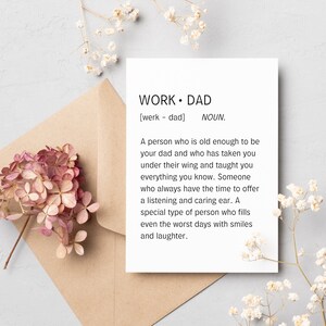 Può includere: Un biglietto con la definizione della parola "Papà" come una persona abbastanza grande per essere tuo padre e che ti ha preso sotto la sua ala e ti ha insegnato tutto ciò che sai. Il biglietto è su una busta marrone con fiori rosa.