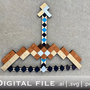 Op de afbeelding: Een houten boog en pijl, gemaakt van verschillende gekleurd hout, met een blauwe en zwarte pijl. De boog is gevormd als een Minecraft boog en pijl.
