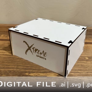 Op de afbeelding: Witte houten doos met een zwarte rand en een gouden logo met de tekst "XTREME SPORTS".