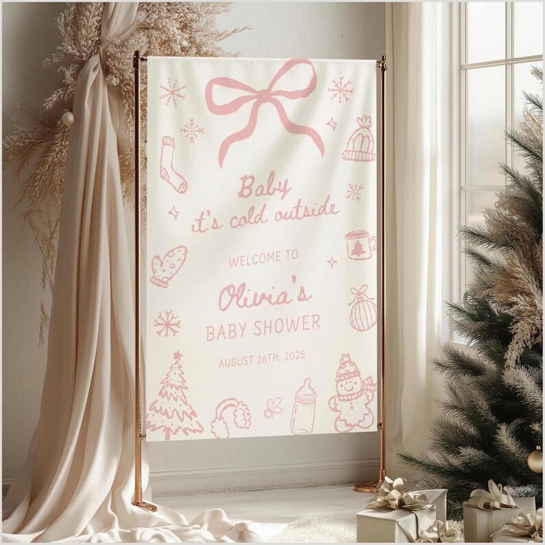 May include: A baby shower banner with a light background and pink illustrations of snowflakes, a bow, and winter-themed items. The text reads "Baby it's cold outside" and welcomes guests to Olivia's baby shower on August 26th, 2025.