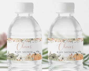 May include: Two clear plastic water bottles with labels featuring a fall-themed design. The labels have a floral border with pumpkins, leaves, and the text "Olivia's Baby Shower".