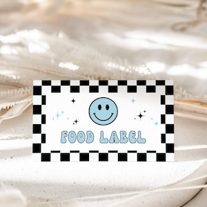May include: A rectangular food label with a black and white checkered border. The label features a light blue smiley face and the words "FOOD LABEL" in a matching light blue font, with star accents.