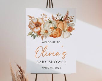 May include: Welcome to Olivia's Baby Shower sign with a watercolor illustration of pumpkins and flowers in shades of orange, white, and green. The text reads "Welcome to Olivia's Baby Shower April 15, 2023".