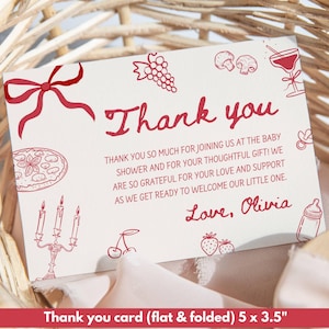 May include: A white thank you card with red text and illustrations, including a bow, grapes, mushrooms, and a cocktail. The card reads "Thank you" and includes a message about a baby shower. The card is 5 x 3.5 inches.