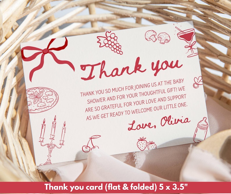 May include: A white thank you card with red text and illustrations, including a bow, grapes, mushrooms, and a cocktail. The card reads "Thank you" and includes a message about a baby shower. The card is 5 x 3.5 inches.