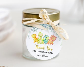 May include: A round, white thank you tag with a green leafy border and four colourful dinosaurs. The tag says "Thank You for coming to my party Love, Olivia".