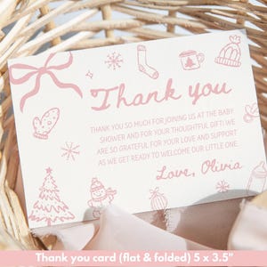 May include: A flat, folded baby shower thank you card with pink text and illustrations. The card reads "Thank you" and includes a message of gratitude, signed "Love, Olivia." The card measures 5 x 3.5 inches.