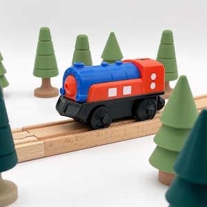 May include: A red, blue, and black toy train engine with white details on a wooden train track. The train is surrounded by green toy trees.