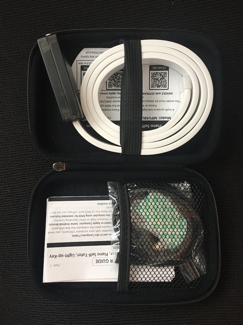 Peut inclure: Un &eacute;tui de transport noir zipp&eacute; contenant une bande lumineuse blanche enroul&eacute;e pour piano, un bo&icirc;tier de commande noir, un manuel d'utilisation imprim&eacute; et une petite poche en filet avec un composant adh&eacute;sif vert pour syst&egrave;me d'apprentissage.