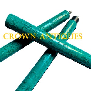 May include: Two teal blue walking sticks with nautical themed embossed designs. The sticks are crossed over each other and the text "CROWN ANTIQUES" is visible in the background.