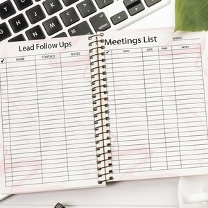 May include: An open spiral bound notebook with two pages. The left page has the title "Lead Follow Ups" with columns for name, contact, and notes. The right page has the title "Meetings List" with columns for month, topic, date, time, and notes.