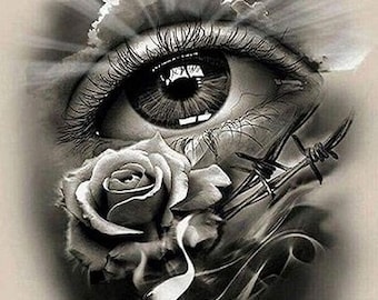 Può includere: Un design di tatuaggio in bianco e nero con un grande occhio, una rosa e filo spinato. L'occhio guarda verso l'alto, verso un cielo nuvoloso con raggi di luce che brillano verso il basso.