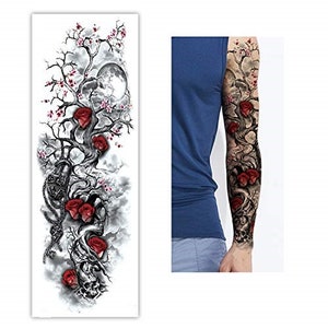 May include: A temporary tattoo design featuring a black and white tree with red roses and a moon. The tattoo is designed to be applied to the arm.