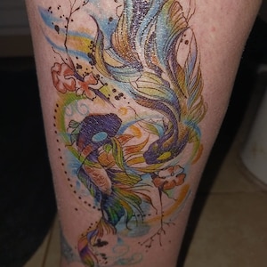 May include: A colorful temporary tattoo of a fish with watercolor-like details. The fish is surrounded by flowers and swirls.