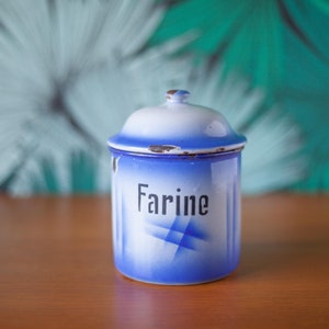 Puede incluir: Un tarro de esmalte azul y blanco con tapa. El tarro tiene un diseño geométrico blanco y azul y la palabra "Farine" impresa en la parte delantera.