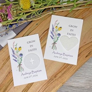 May include: Two white cards with a floral design and the text "Grow in Faith". The cards have a small circle and a heart shape cut out of them. The text "Audreys Baptism June 21st, 2024" is printed on the bottom of each card.