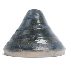 Könnte beinhalten: Eine schwarze, kegelförmige Vase aus Keramik mit einer strukturierten Oberfläche und einem braunen Rand.