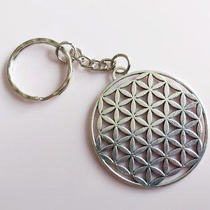 Sleutelhanger met levensbloem. Grote zilverkleurige heilige geometrie oude wiskundige sleutelhanger.