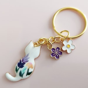 White flower cat keyring. Small enamel feline floral charm with daisy and sakura flowers. Gold tone split keychain for cat & garden lovers.