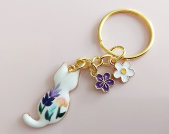 White flower cat keyring. Small enamel feline floral charm with daisy and sakura flowers. Gold tone split keychain for cat & garden lovers.