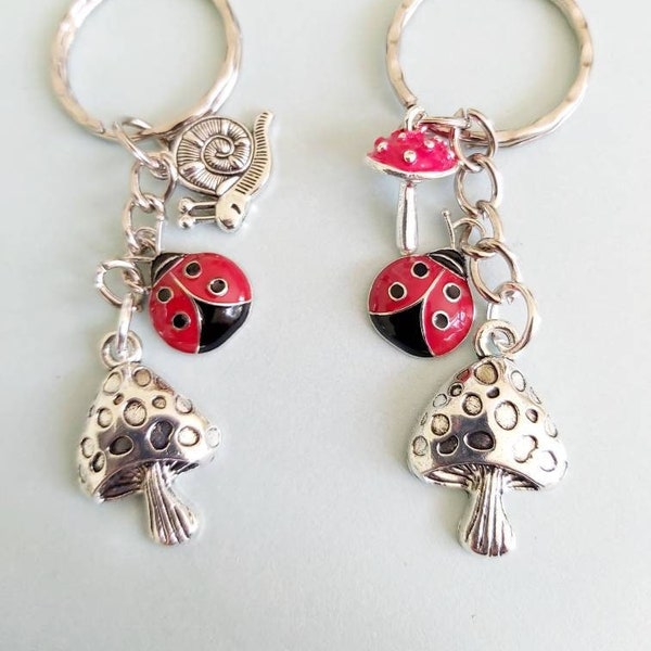 Red ladybird mushroom keyring. Enamel and silver tone charms on a silver tone split keyring. Ladybug woodland mushroom fungi keychain.