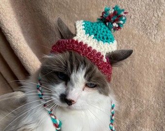Berretto a forma di gatto all'uncinetto: berretto festivo con pompon verde, rosso e bianco
