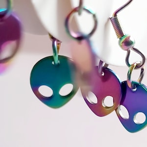 Little alien earrings. Rainbow iridescent electroplated stainless steel space being charms. Abstract alien face. Simple elegant design.