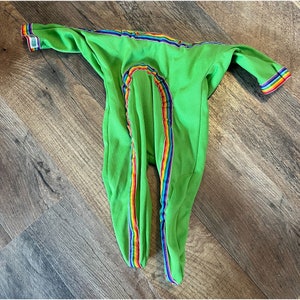 May include: Green one-piece sleeper with rainbow stripes down the legs.