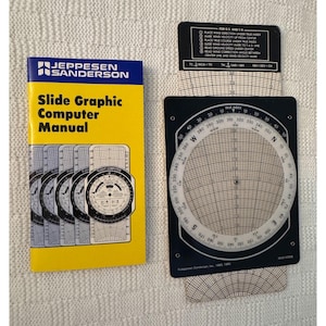 May include: A yellow and black manual for a slide graphic computer, with a close-up of the computer itself. The computer is a circular device with a black face and white markings. The manual has the title "Slide Graphic Computer Manual" and the company name "Jeppesen Sanderson".