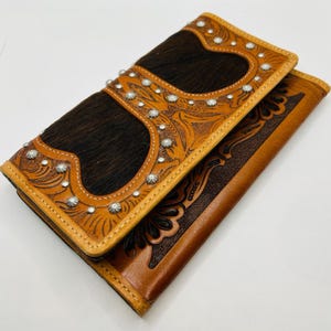 Cartera de cuero marrón estilo western con tachuelas y detalles de pelo de vaca