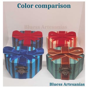 Op de afbeelding: Vier decoratieve, zeshoekige dozen met streepjespatronen en fluwelen strikken. De dozen zijn in blauwe, rode en groene tinten, met messingkleurige sluitingen. De tekst "Color comparison" en "Bluess Artesan&iacute;as" is zichtbaar.