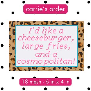 Può includere: Una tela rettangolare per ricamo con un bordo leopardato e un centro bianco con testo pixelato rosa che recita: I'd like a cheeseburger, large fries, and a cosmopolitan! La tela è etichettata come 18 mesh e 15,24 cm x 10,16 cm.