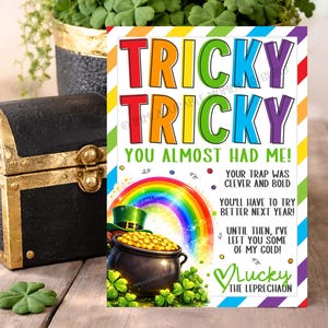 May include: A St. Patrick's Day greeting card with the words "Tricky Tricky" in rainbow colors. The card features a pot of gold, a rainbow, and the text "You almost had me!" and "Lucky the Leprechaun."