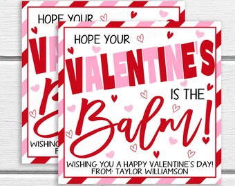 May include: Two pink and red Valentine's Day gift tags with white background and pink and red hearts. The text reads "Hope your Valentine's is the Balm!" and "Wishing you a happy Valentine's Day! From: Taylor Williamson".